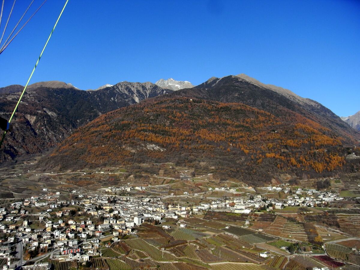 Panorama di Ponte in Valtellina visto da nord, con il borgo e i vigneti terrazzati circondati dalle montagne